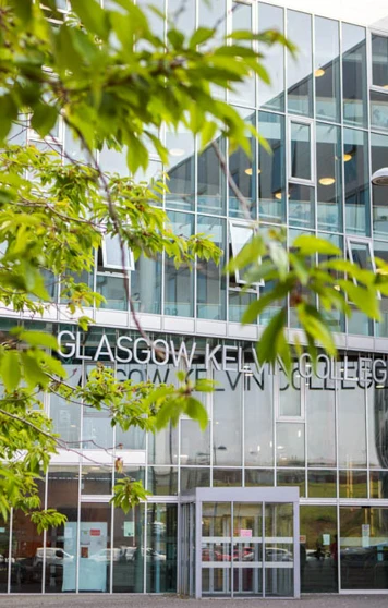 View of Glasgow Kelvin College Springburn Campus entrance seen through leafy trees, showcasing the building’s modern exterior. View of Glasgow Kelvin College Springburn Campus entrance seen through leafy trees, showcasing the building’s modern exterior.